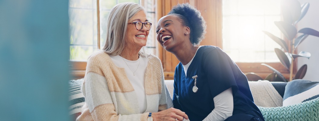 Älterer Patient, freundlicher oder fröhlicher Pflegekraft, der in einer Pflegeheimklinik über Gesundheitsversorgung spricht. Lächeln, Frauen lachen oder Krankenschwester erzählt einer älteren Person oder Frau in einem freundlichen Gespräch einen Witz.