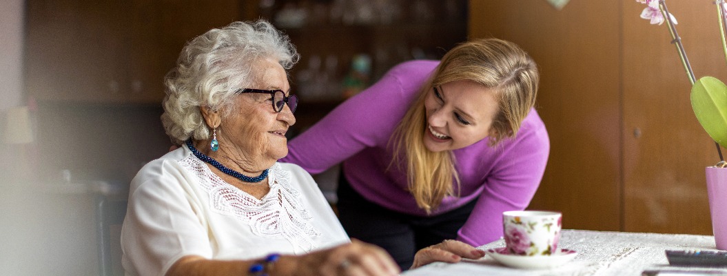 Young woman spending time with her elderly grandmother at home