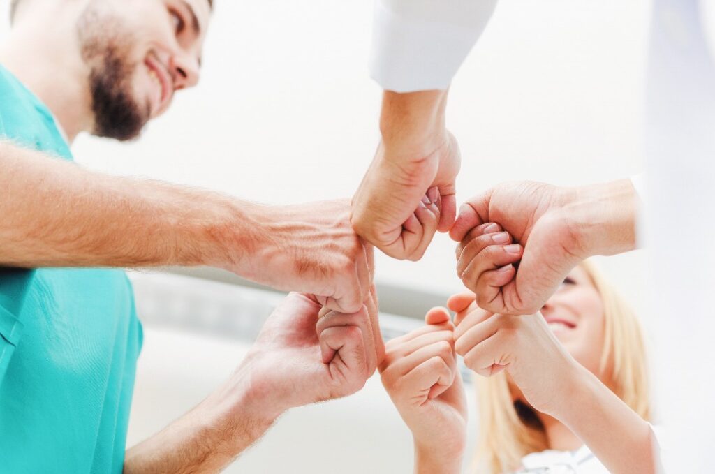 Arzt, Chirurg und Krankenschwester arbeiten Hand in Hand.