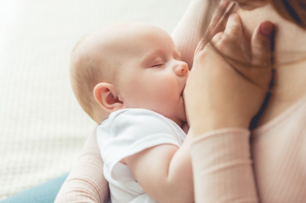 Ausschnitt einer Mutter, die ihr Kind in einer Wohnung stillt