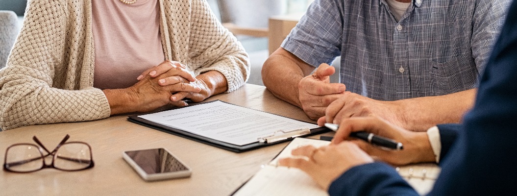 Ein älteres Ehepaar plant gemeinsam mit einem Finanzberater seine Geldanlagen