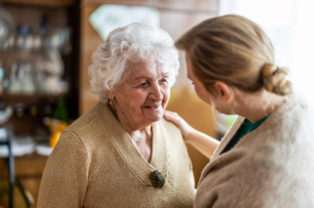 Health visitor talking to a senior woman during home visit