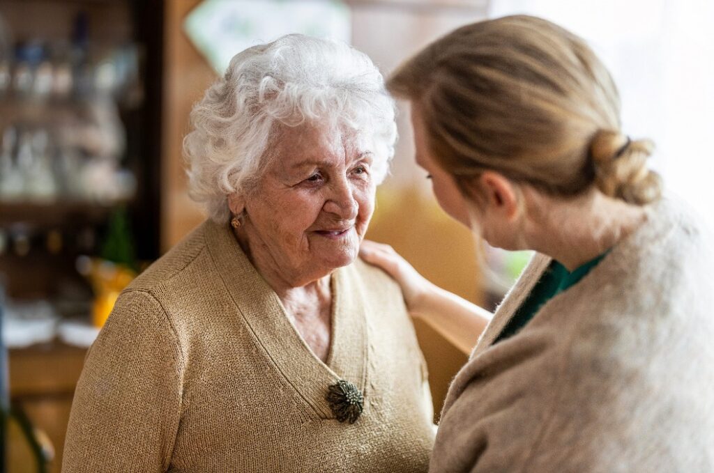 Health visitor talking to a senior woman during home visit