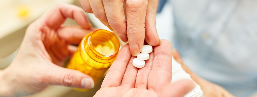 Pflegedienst verteilt Tabletten an Patient