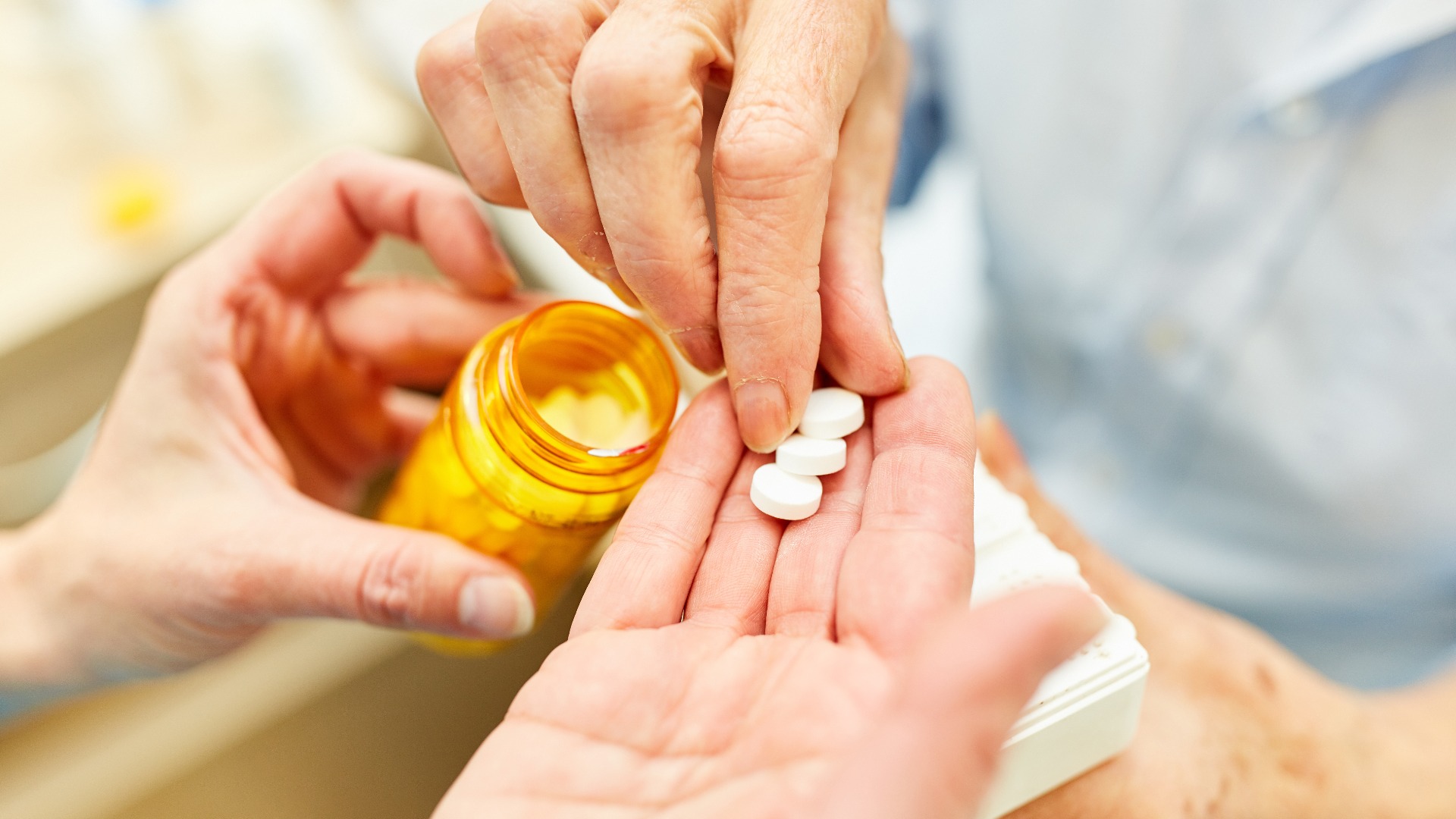 Pflegedienst verteilt Tabletten an Patient