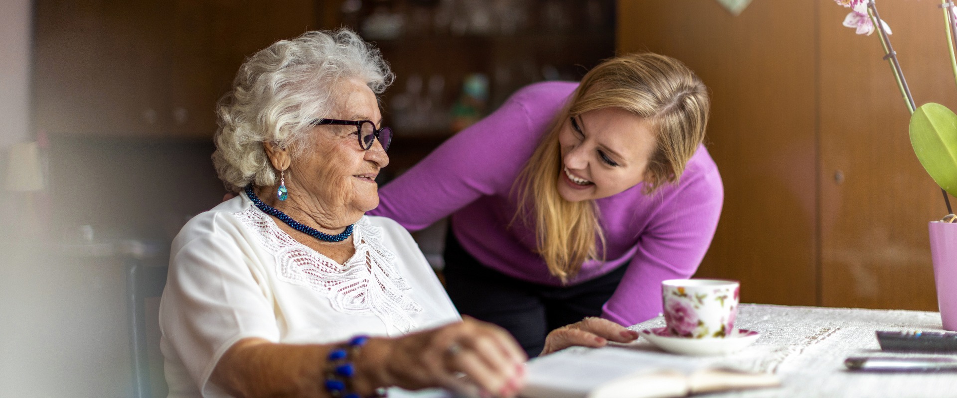 Young woman spending time with her elderly grandmother at home